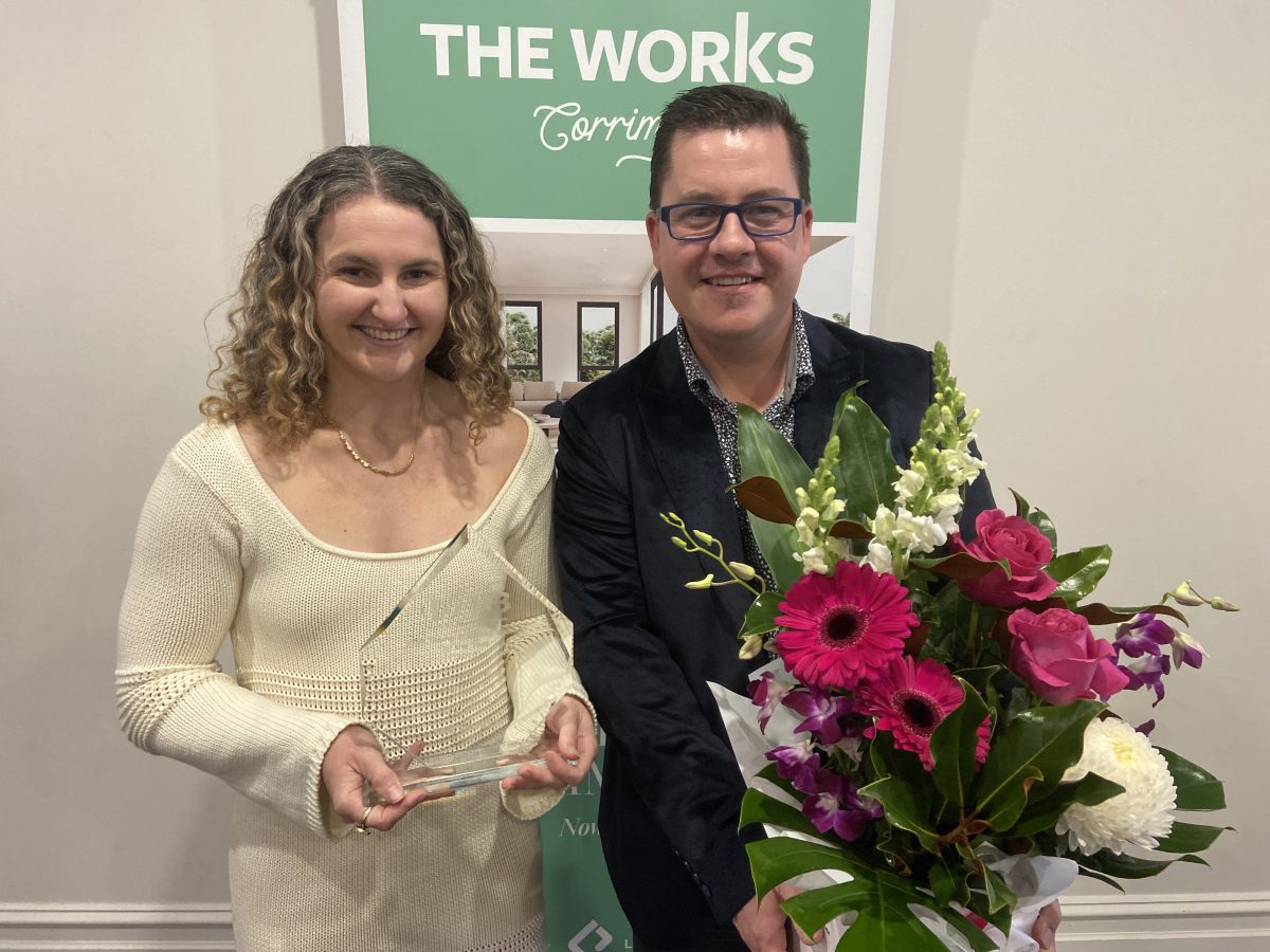 a woman and a man with an award and flowers