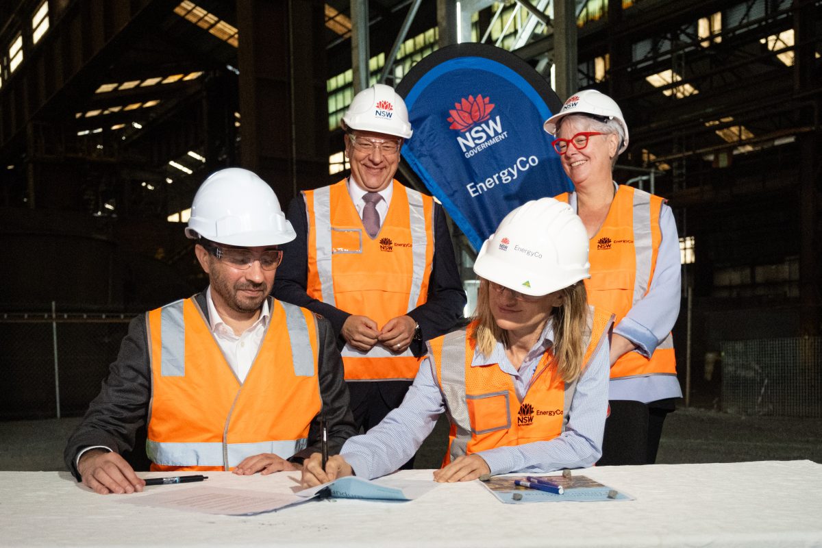 People in hi-vis vests and hard hats sign a memorandum at the Launch of the Illawarra REZ