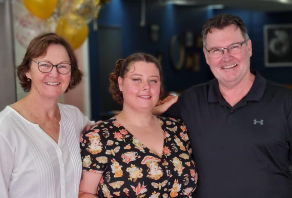 two women and a man standing in a row