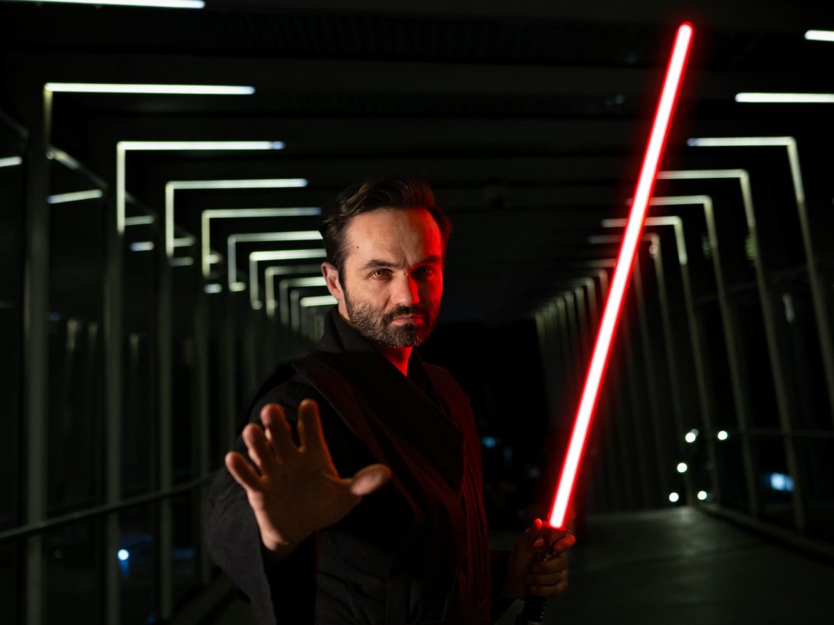 Man in costume weilding lightsaber