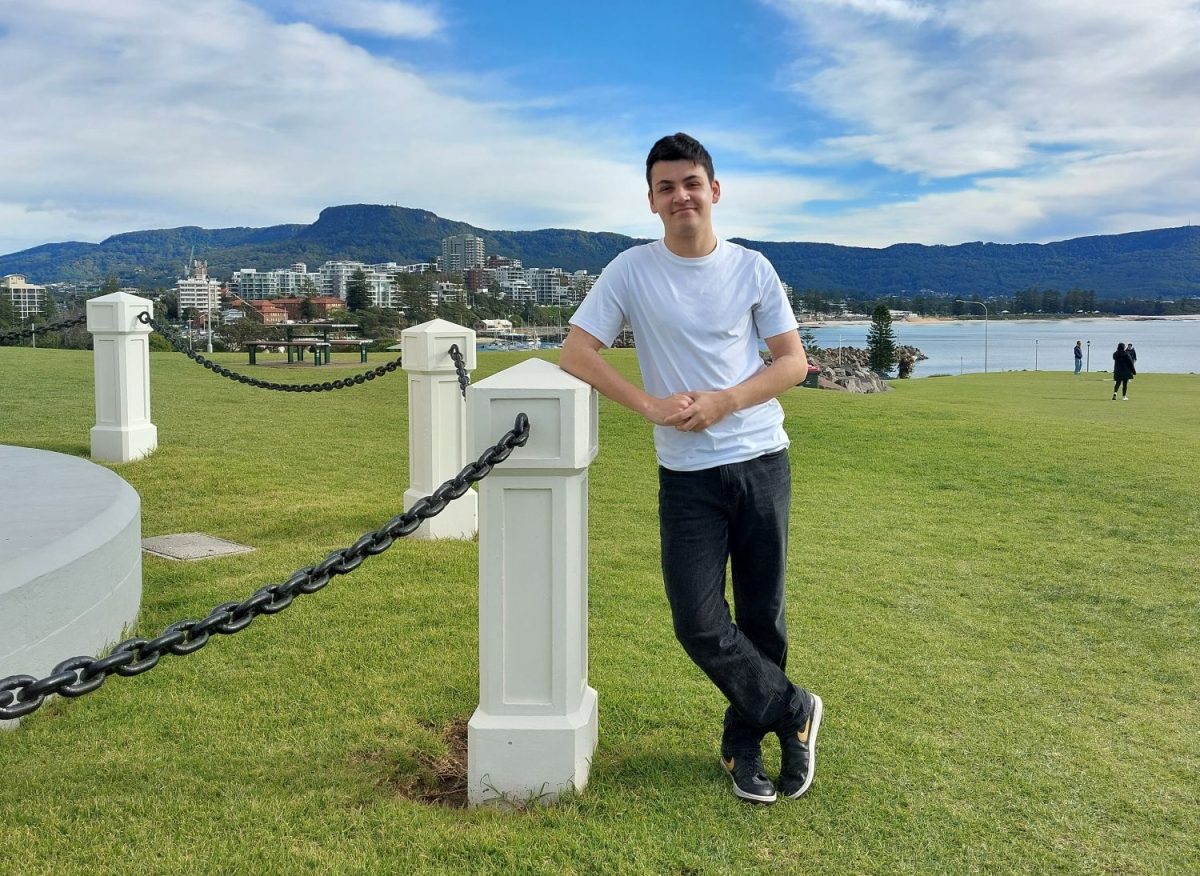 Teenager leaning on chain fence