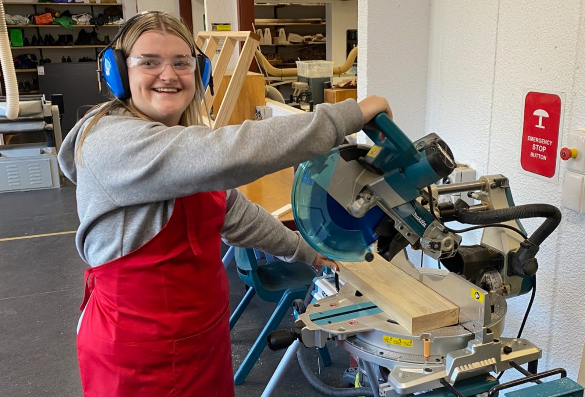 teenage girl using a bench saw