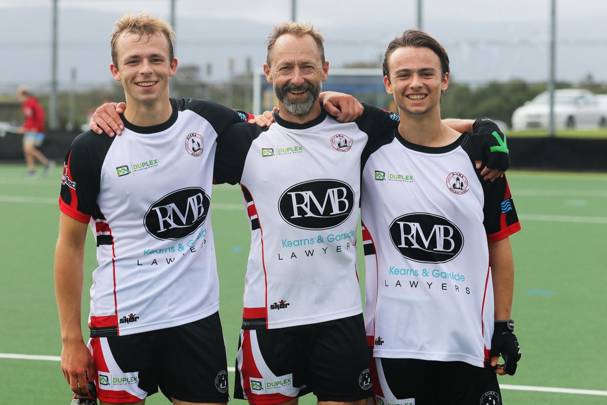 three male field hockey players
