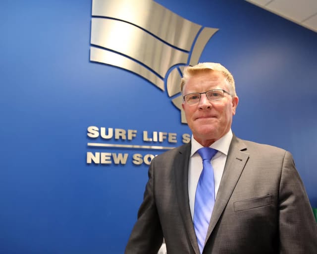 Man in front of surf life saving background