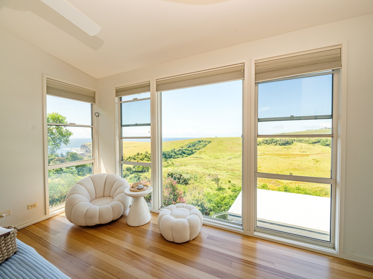 Sitting room overlooking grassy cliff and ocean