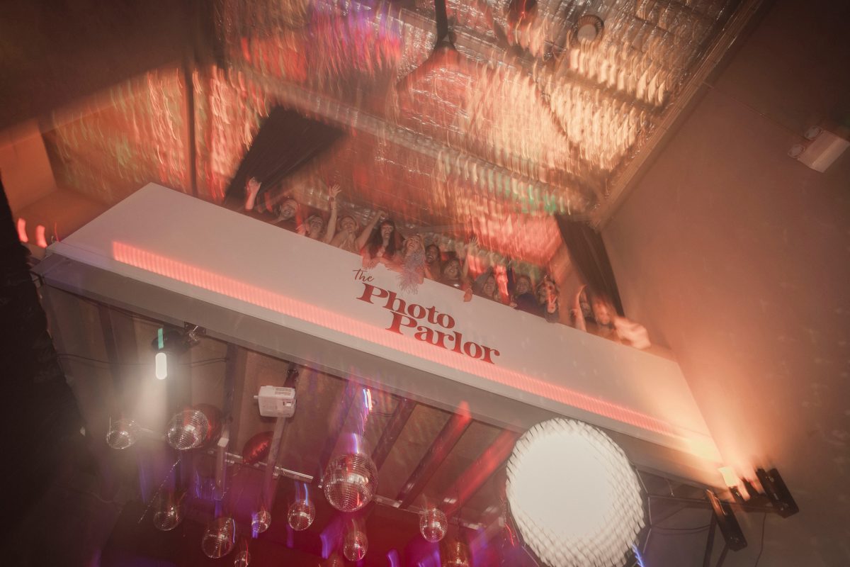 The Photo Parlor sign with party-goers