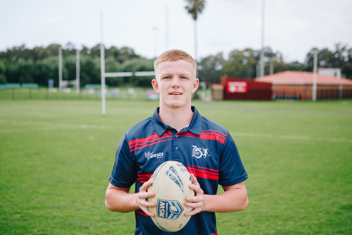 Kade Reed of the Wests Devils stands on the footy field holding a football