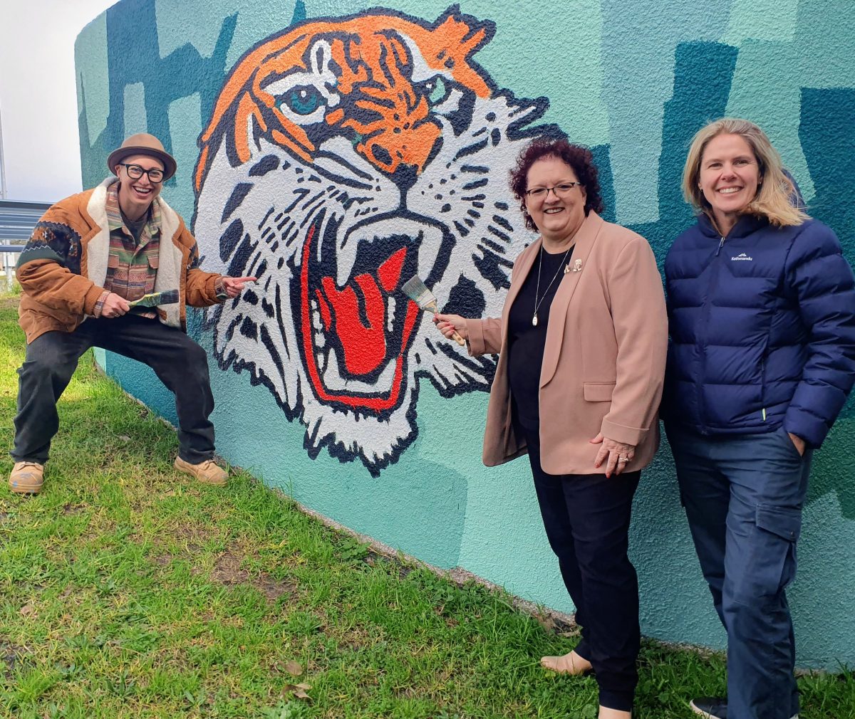 Artist Sarah Rowan, Lord Mayor Tania Brown and councillor Jess Whittaker at one of the newly-painted tanks on Rex Jackson Oval.