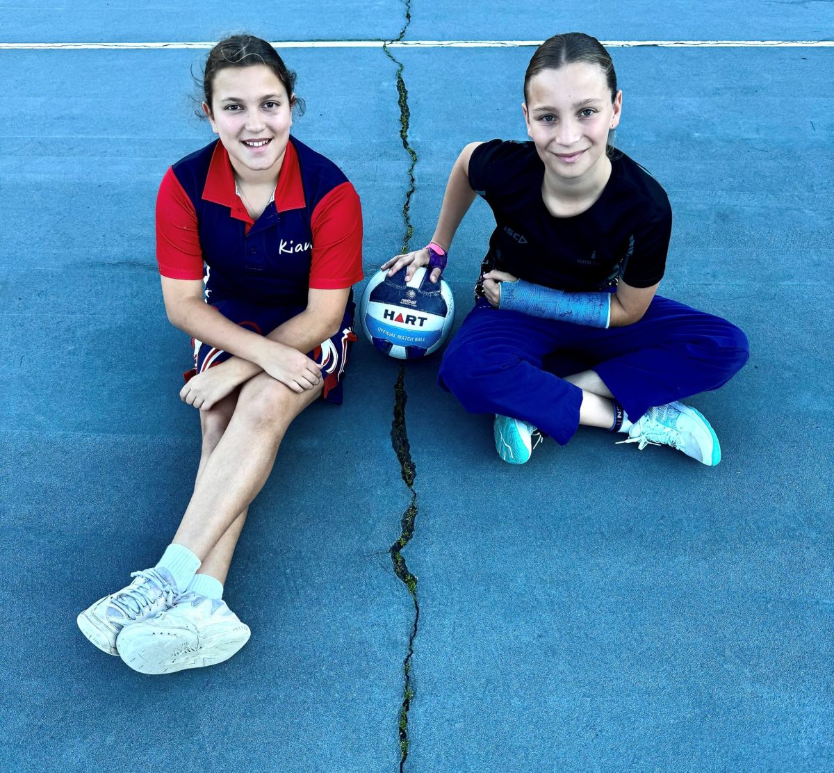 Young Kiama netballers Ivy and Archie Turano-Lyall with one of the cracks in the courts at the Kiama Netball Courts