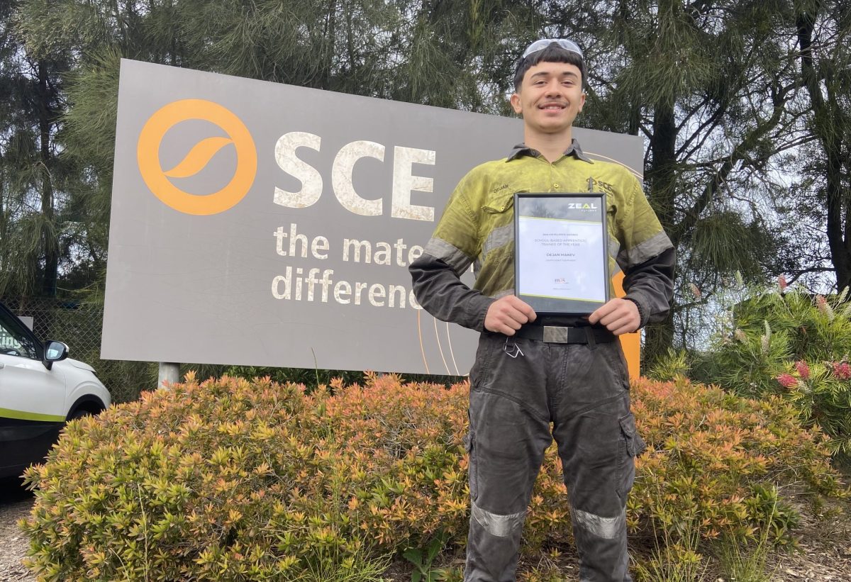 Dejan Manev stands in front of a South Coast Equipment Sign