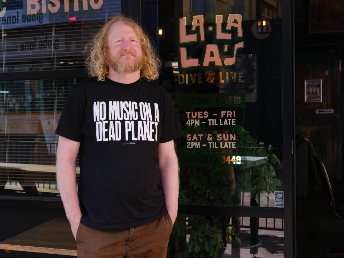 man standing in front of a music venue