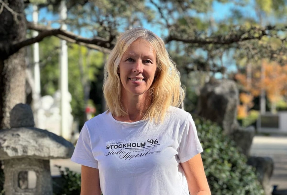 blonde woman standing outdoors and wearing a white T-shirt