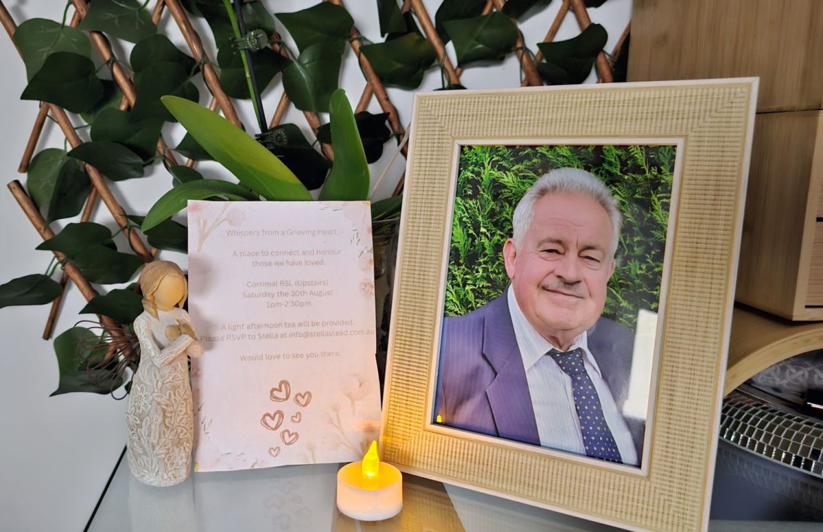 Framed photo of a man next to a candle and memorial notice