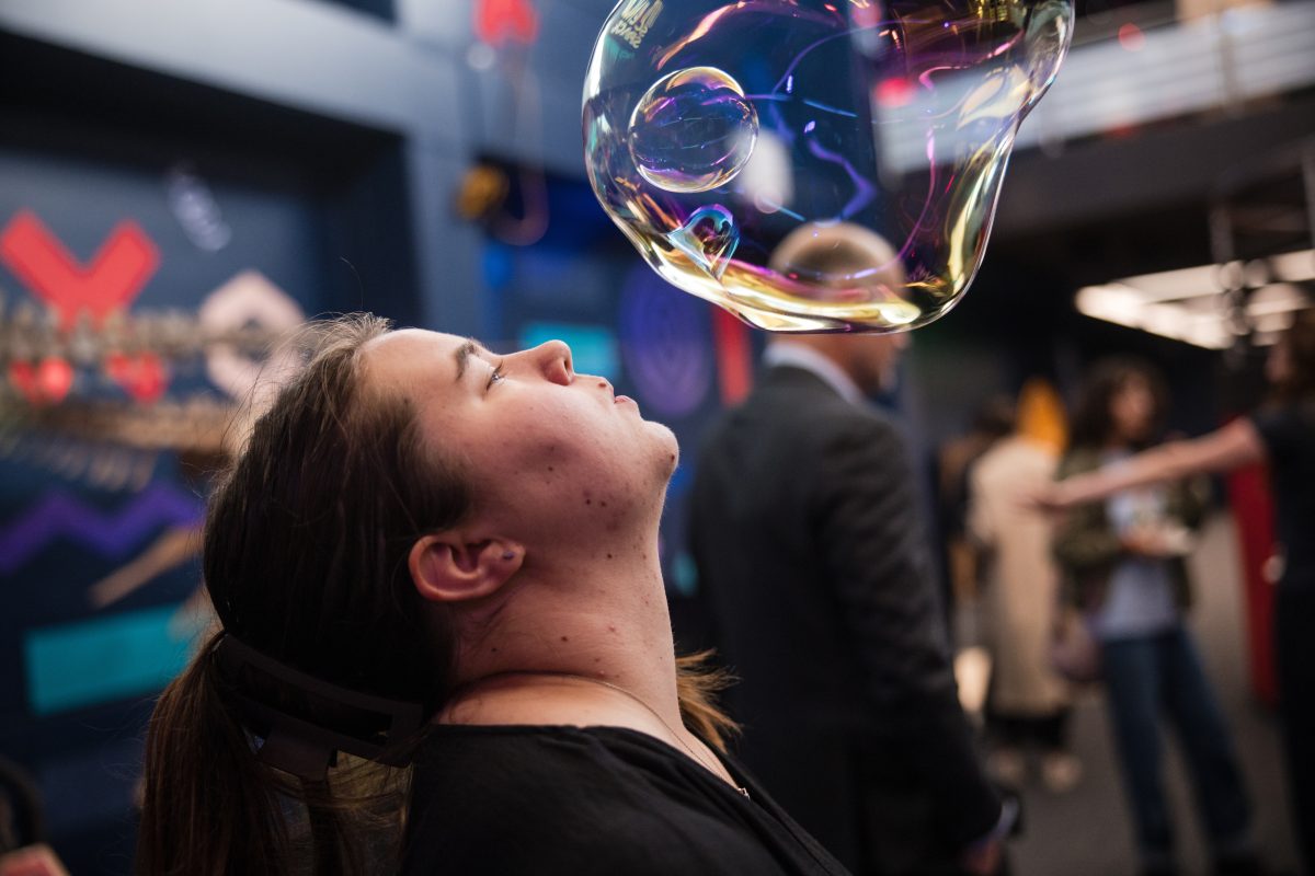 A woman blows a giant bubbles at University of Wollongong's Science Space