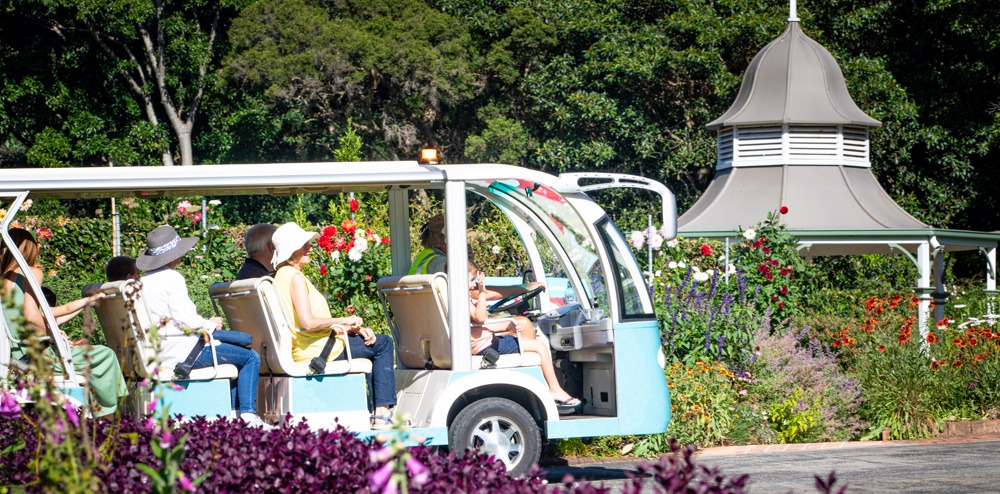 people sitting in a buggy touring gardens