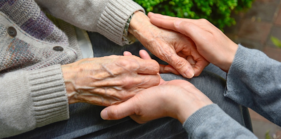 A pair of hands holding onto another pair of older hands
