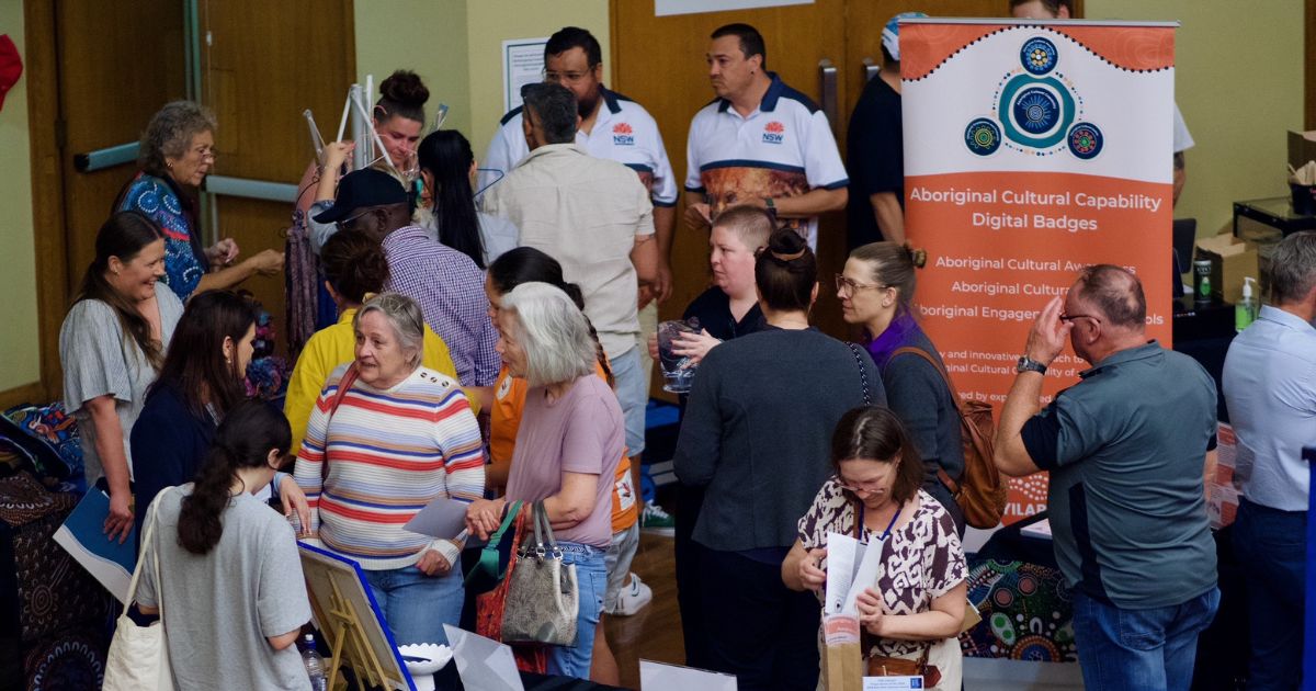 a crowd of people walking through an expo