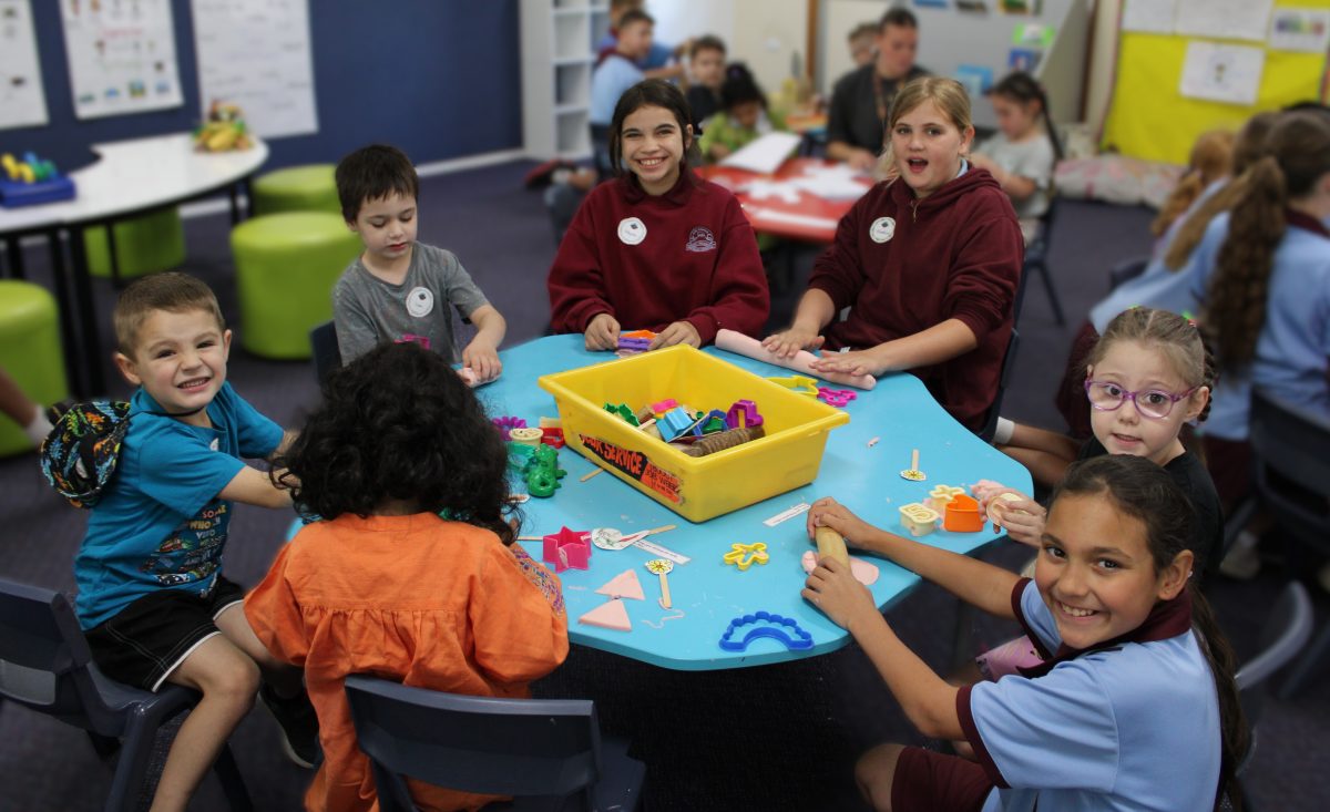 Preschooler and Year 5 kids play at kindergarten orientation.