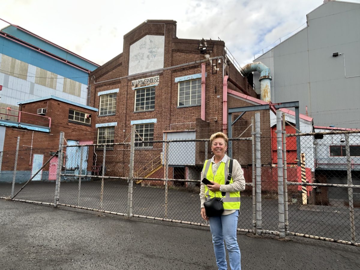 Franca Facci stands in front of an old warehouse in Port Kembla