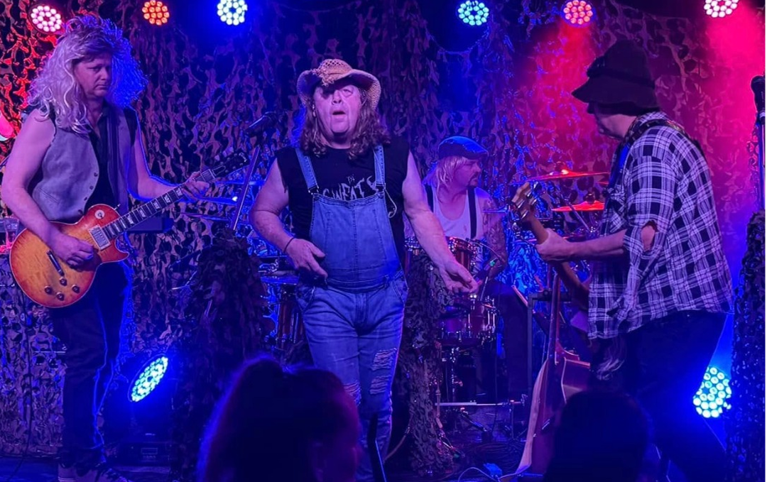 a band with musical instruments on stage bathed in blue and pink lights