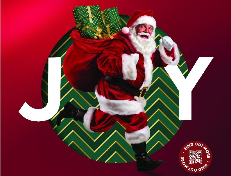 Santa runs with his sack of toys in front of the word "joy"