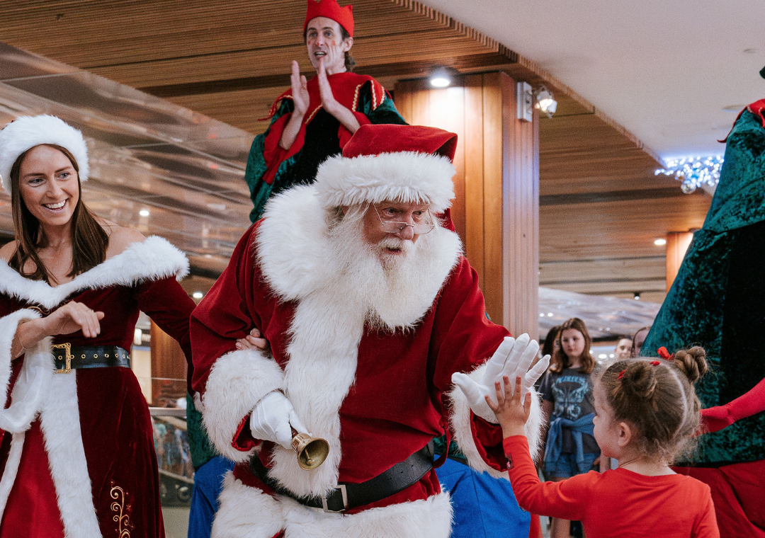 Santa hi fives a little girl