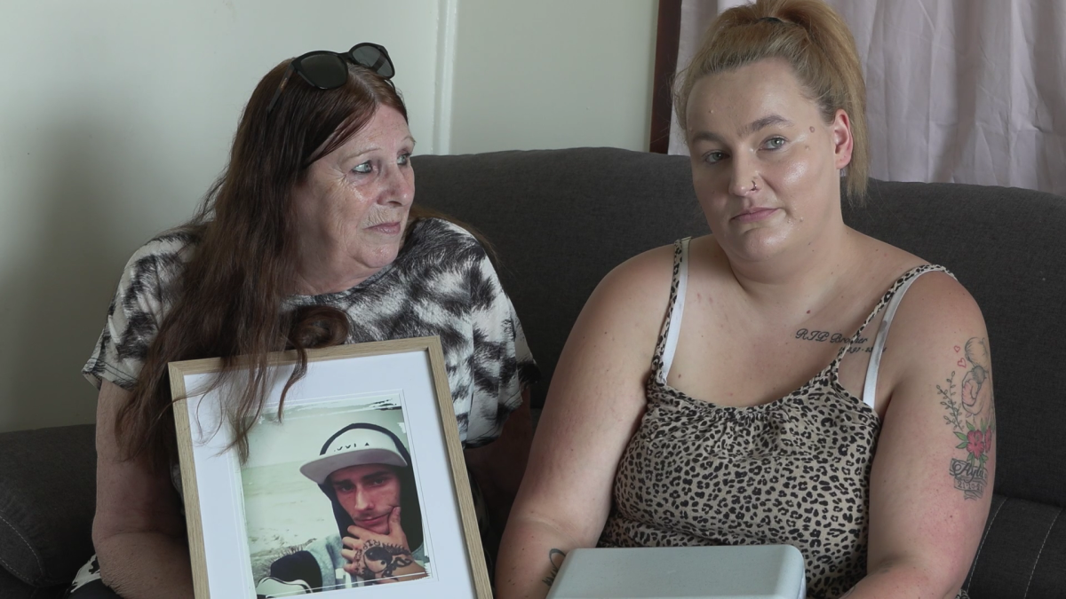 two women with a photo of a male family member