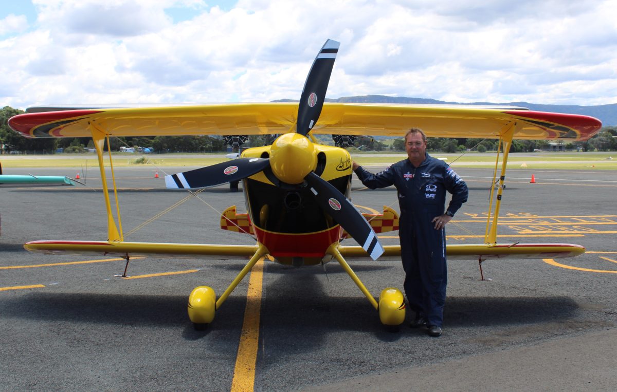 Paul Bennet standing next to yellow plane.