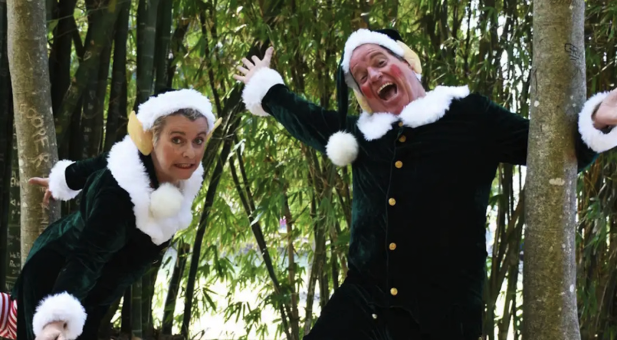 Two people dressed as elves and posing among bamboo