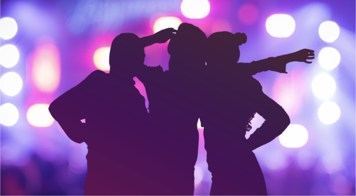 Silhouette of people against purple lights