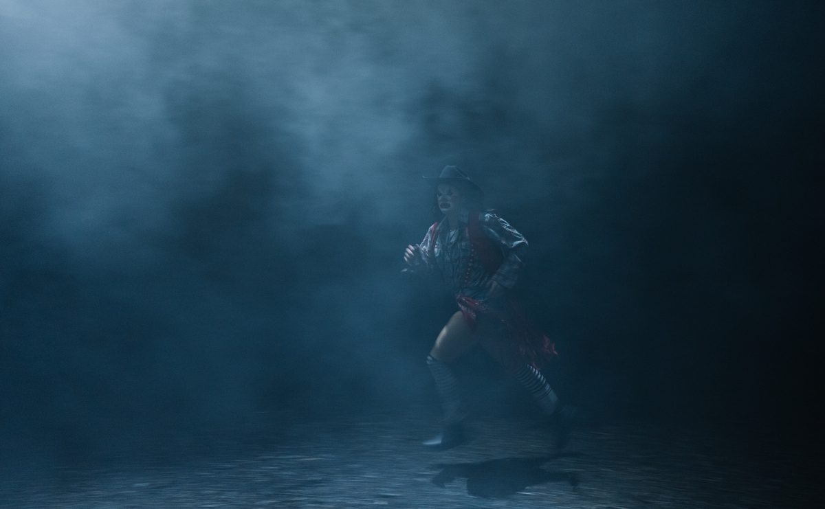 Vyvyan Hammond dressed as a rodeo clown and running through a misty forest