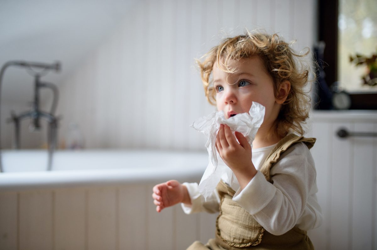 Girl blowing nose with tissue