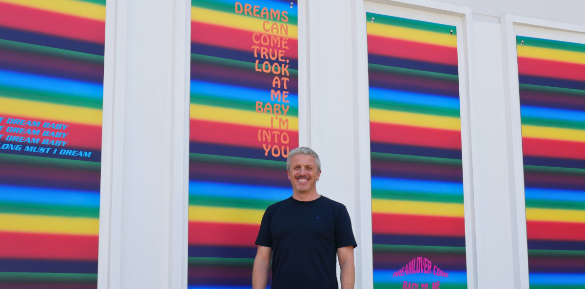 Man in front of colourful painting