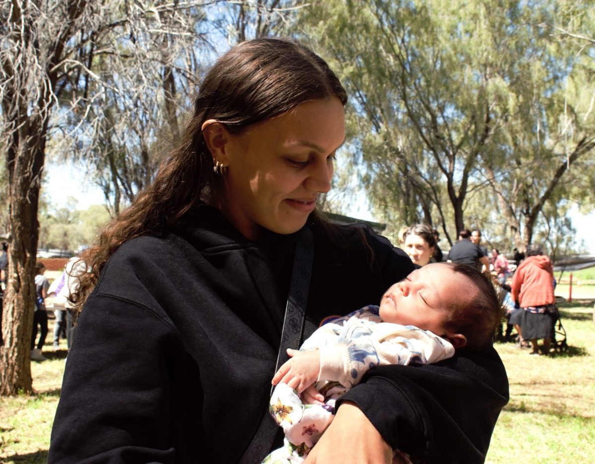 A woman holding a baby outside