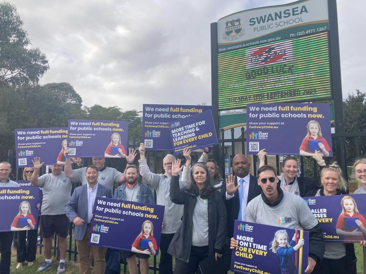 Henry Rajendra standing with teachers in front of the Swansea Public School.