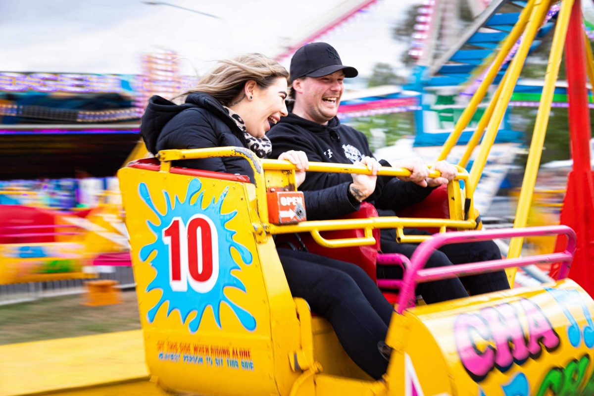 two people enjoying a carnival ride
