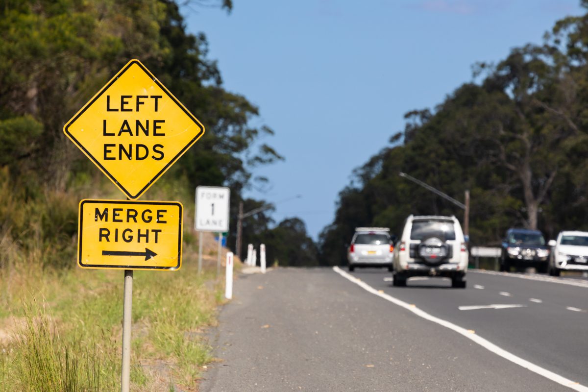 Merge Right traffic sign and cars being driven nearby
